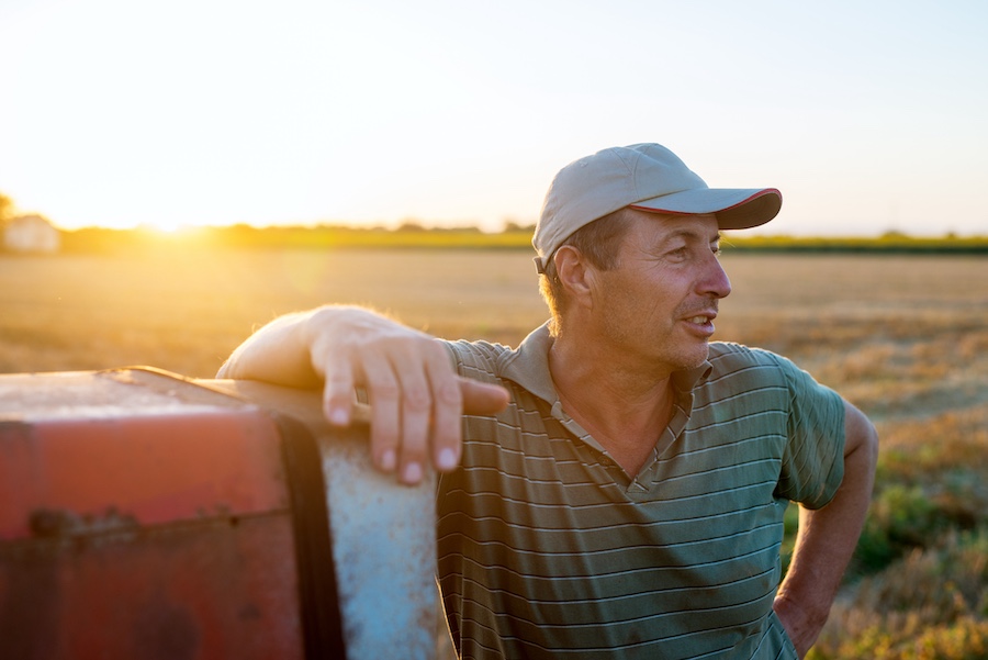 Blue Reef Marketing and Risk Management image of farmer leaning on tractor
